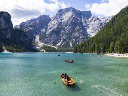 people canoeing on lake braies, dolomite, italy