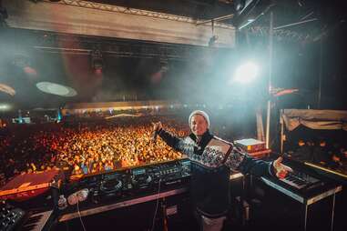 A DJ in a cozy sweater in front of his crowd 