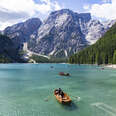 people canoeing on lake braies, dolomite, italy