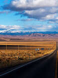 open stretch of us highway 50 in nevada with no cars ahead and blue skies above