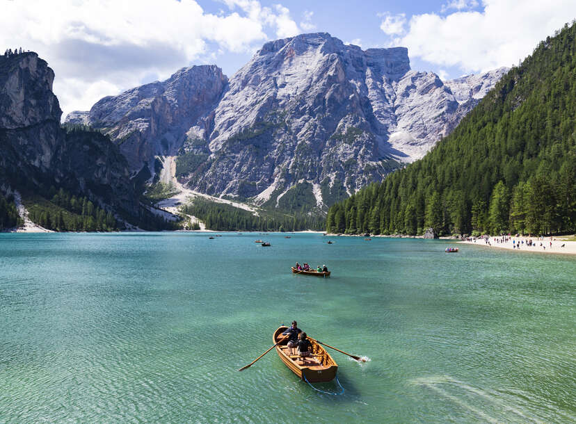 people canoeing on lake braies, dolomite, italy