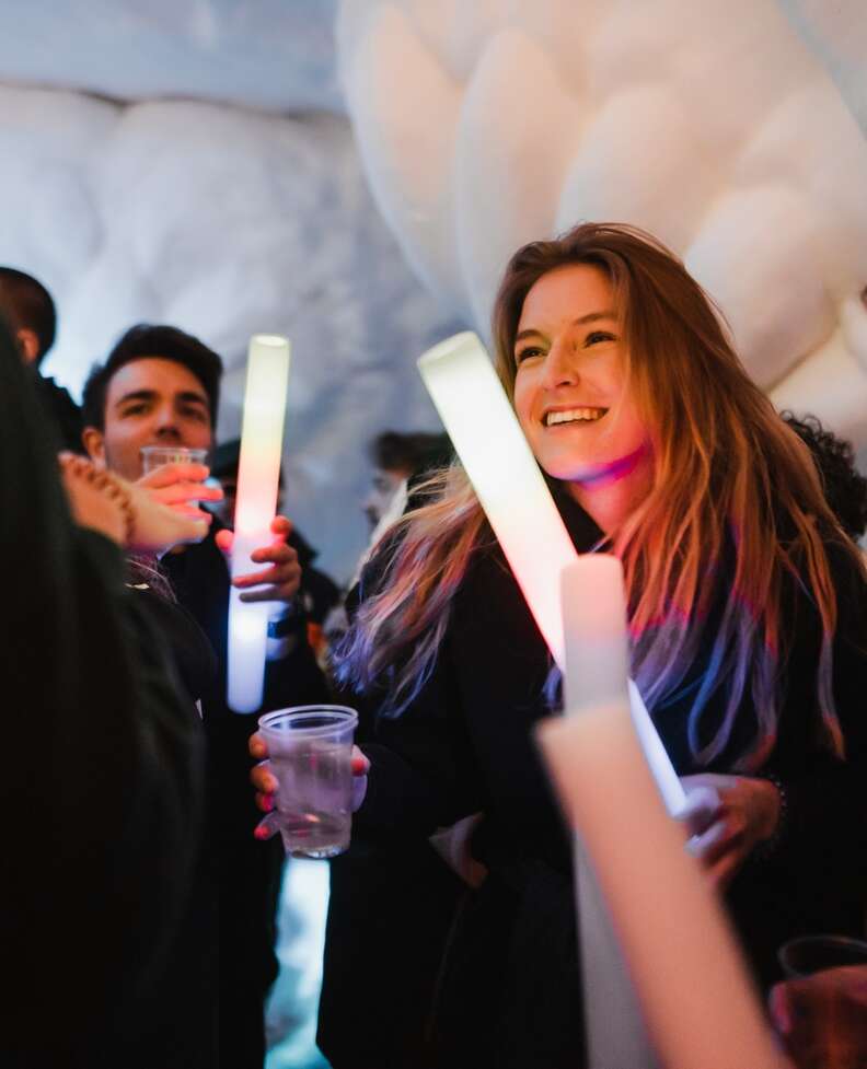 a woman with a large glowstick in an ice cave