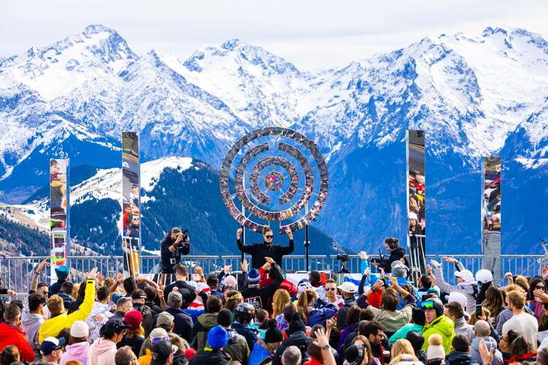 a DJ in front of some snow-capped mountains